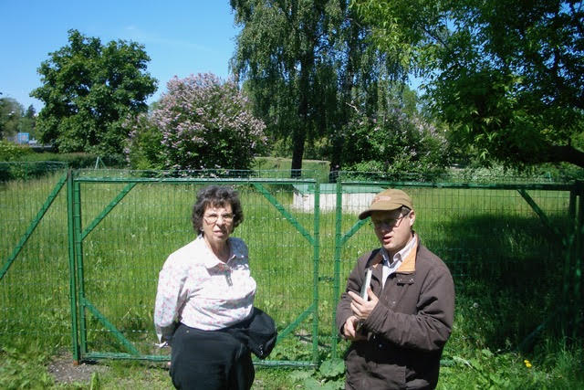 Sally Israel and Aleksandrs Feigmanis in front of a lot where the Synagogue used to be in Bauska
