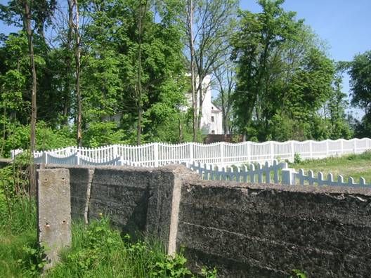Cement fence of it, in the background: Bocki church. May 2005.