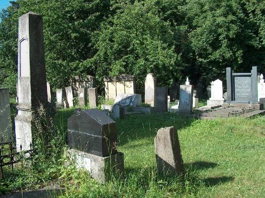 Old headstones and a dark stone in the grass