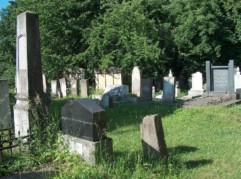Old headstones and a dark stone in the grass