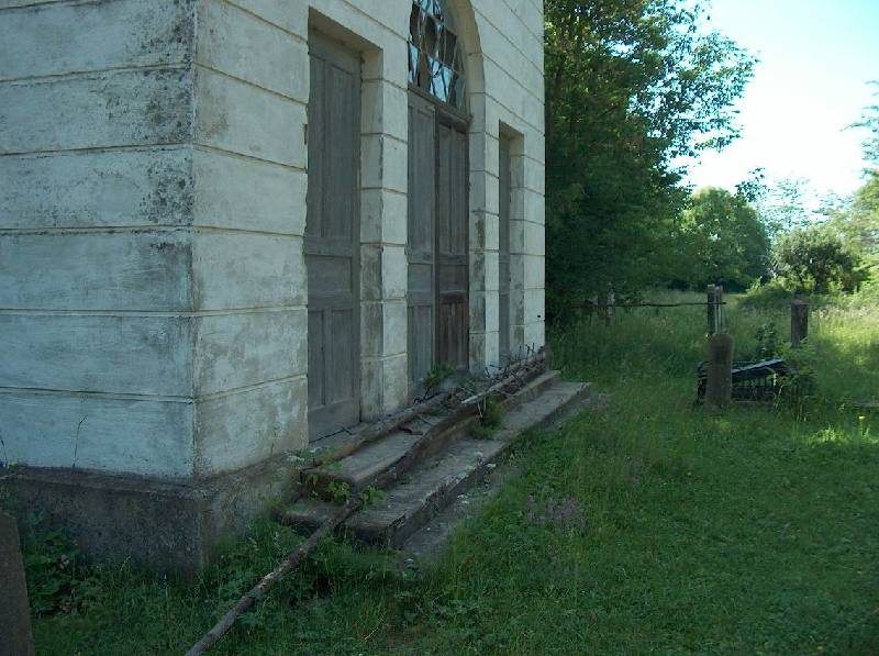 The side wall and doors of a white cemetery building