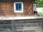 A wooden house in Arbore; the path to the cemetery runs to its left