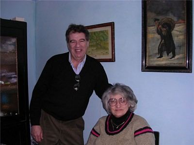 The author with a woman in a room hung with pictures