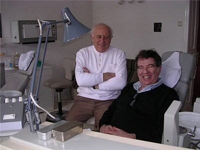 Two men sitting and smiling in an office