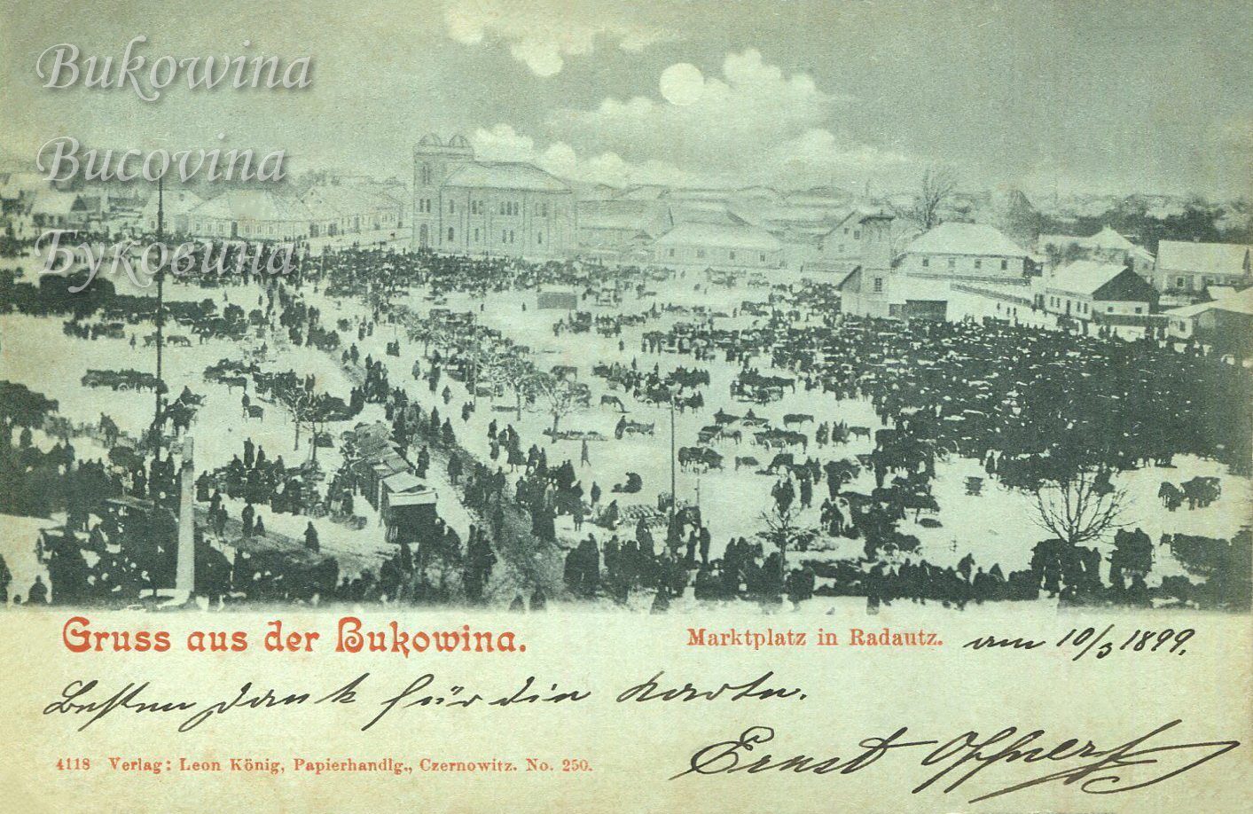Snowy market square crowded with people, horses and sleighs under a moon, the twin-towered temple behind
