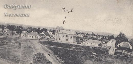 Open square with dirt roads and low houses; a handwritten arrow points to the large twin-towered temple