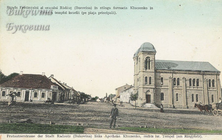 Coloured street scene: low pharmacy building at left, domed temple at right, a man standing and a horse cart