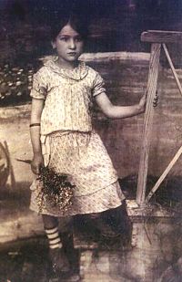 Raizel Lechtzer, circa 1919, standing in front of her house in Stavisht.