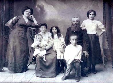 The Lechtzer-Schilmeister Family, Stavisht, 1910-1911. (L-R) Sisters Devorah Butzarksy Schilmeister and Chana Butzarsky Lechtzer, children Raizel, Golda (?) and Herschel, Eli Lechtzer and daughter Miriam Lechtzer Schilmeister (she married Devorah's son, her first cousin). The families had <q>left Stavisht towards Bila Tserkva when news arrived that a pogram was coming their way. My grandfather Eli went back after Shabbes to see what was left of his property. When people came to get the family to take them out of the Ukraine to start their way to America, Herschel went back to get Eli. He saw a Cossack attempting to rape a Jewish woman and got in the middle. Both were killed.</q> <em>Elka Ginsburg-Caplan, daughter of Rose Lechtzer. Elka submitted all the Lechtzer family photos.</em>