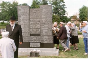 [Rabbi at the monument with some survivors]