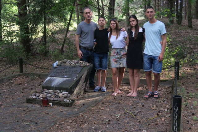 Israel Birenbaum and his family
                                  at the memorial at the site of the
                                  mass grave.