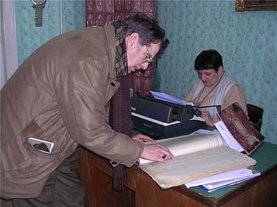 Looking through a record book at the Botosani Jewish Community office