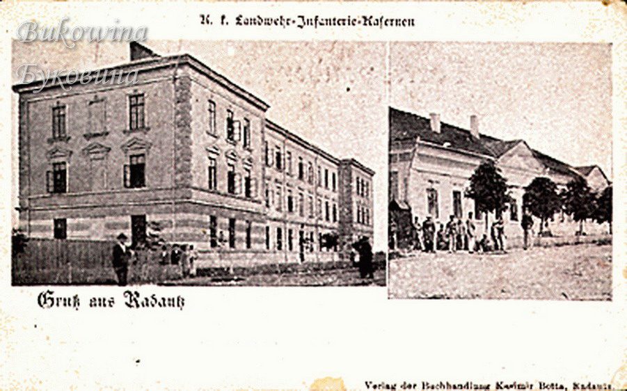 A three-storey barracks block with a few people outside, and a long low building with soldiers gathered by trees