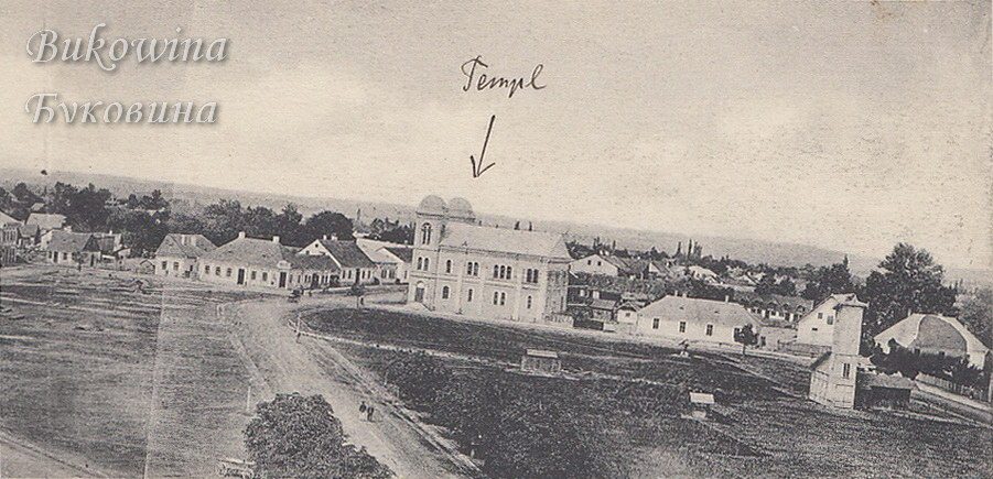 Open square with dirt roads and low houses; a handwritten arrow points to the large twin-towered temple