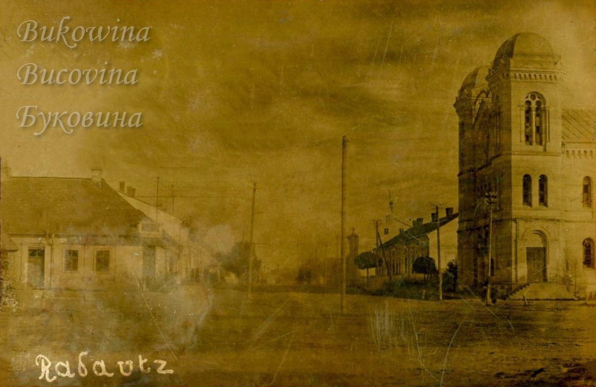 Wide unpaved street with low houses and telegraph poles on the left and the domed temple tower on the right