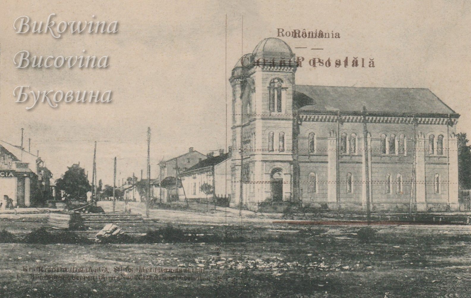 Domed temple with a long arched-window hall at a street corner, low houses and a pharmacy sign at left