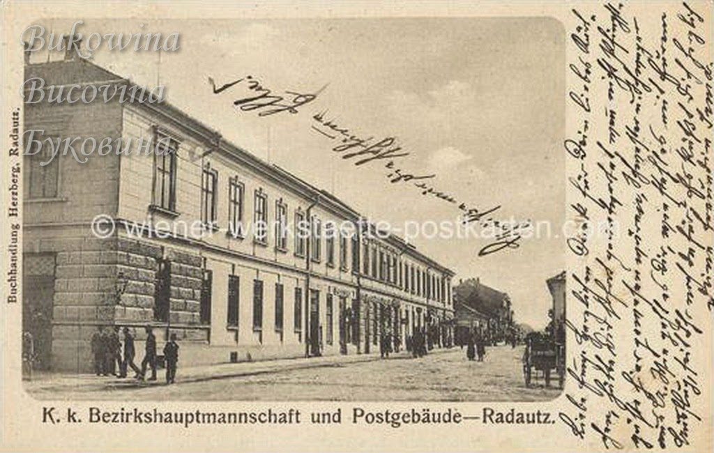 Long two-storey government building along a street, men standing at the corner, handwritten message at right