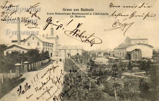 Brewery buildings with a chimney along a lane and a yard with barrels, handwritten greetings across the card